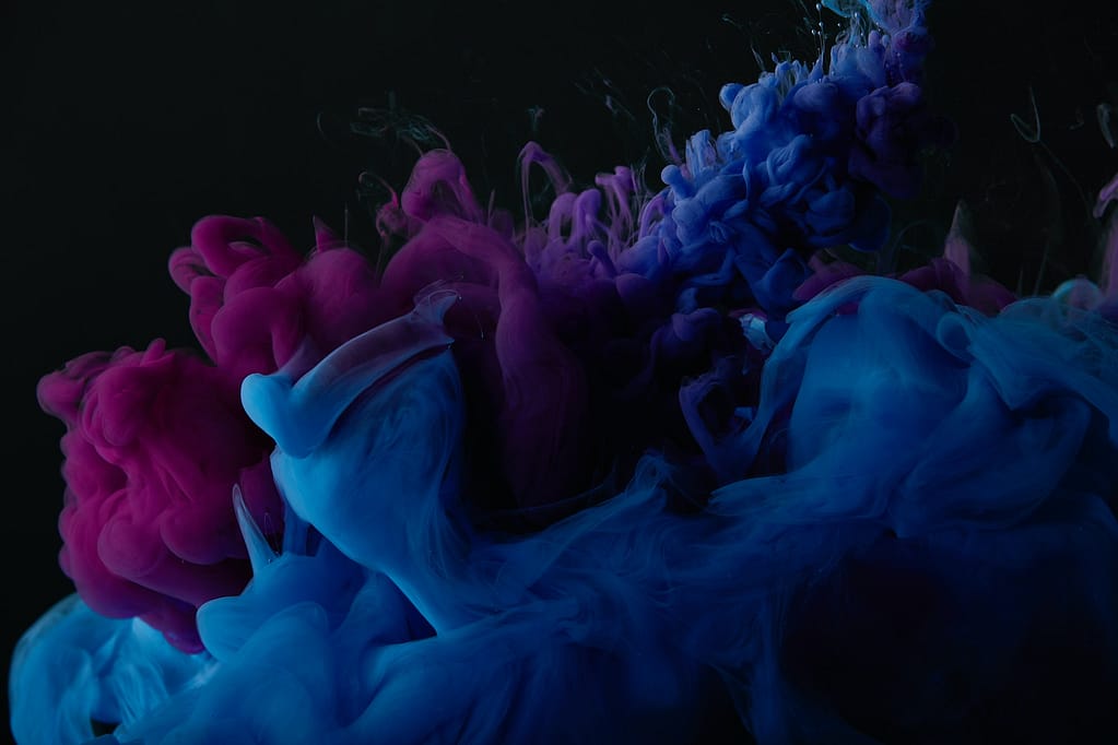 abstract dark texture with blue and purple swirls of paint